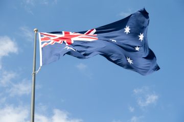 Australian flag against blue sky. High quality photo.